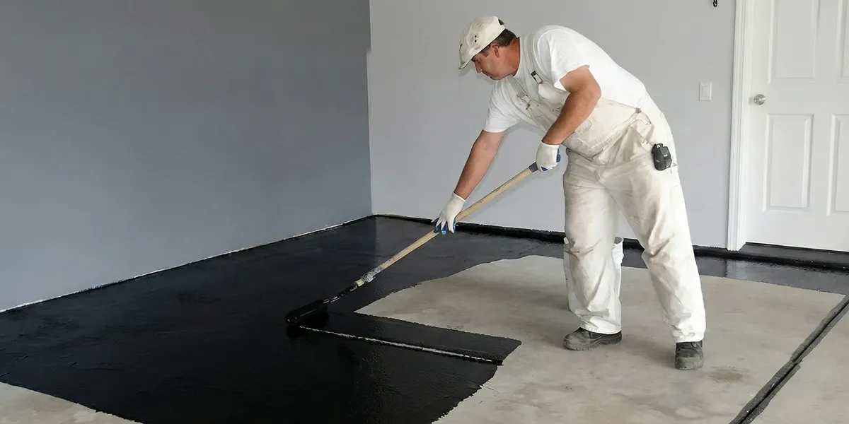 basement waterproofing professional applying waterproof coating to protect a basement floor in San Diego, CA